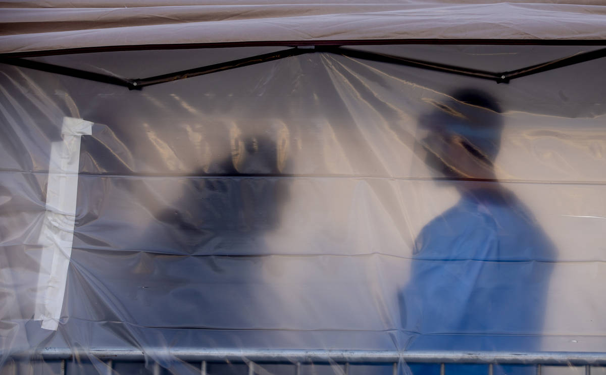 A homeless man enters to have his temperature checked by Touro University Nevada medical studen ...