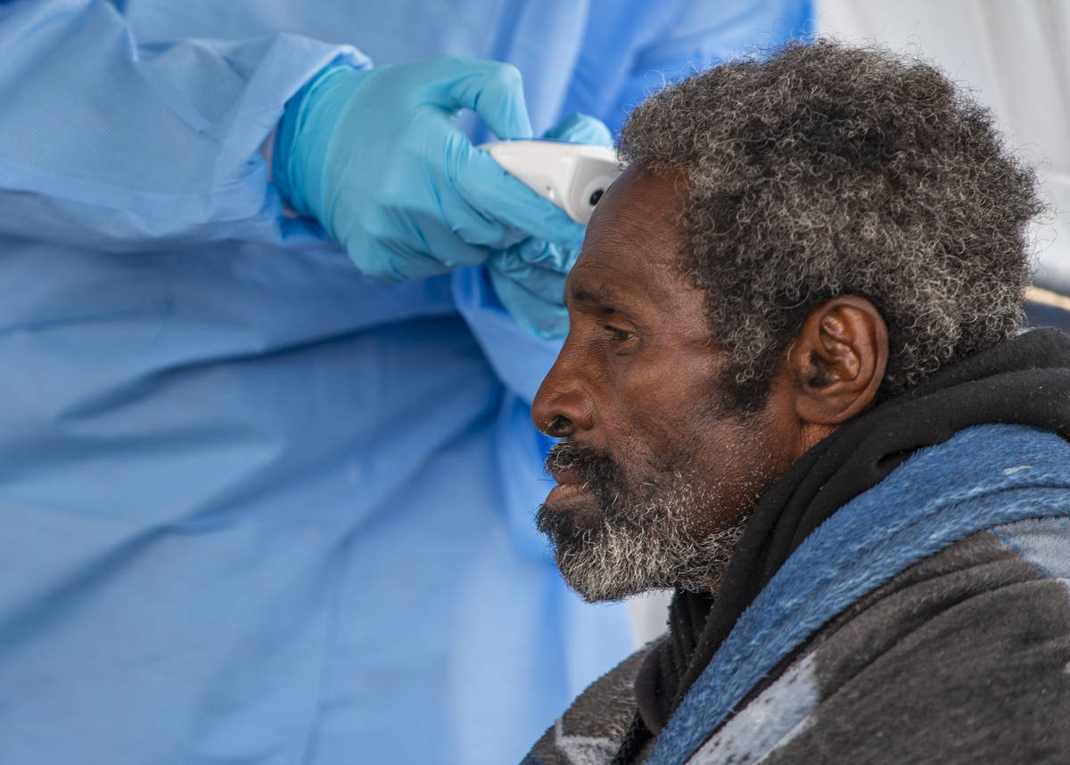 A homeless man has his temperature checked by Touro University Nevada medical student Sami Musa ...