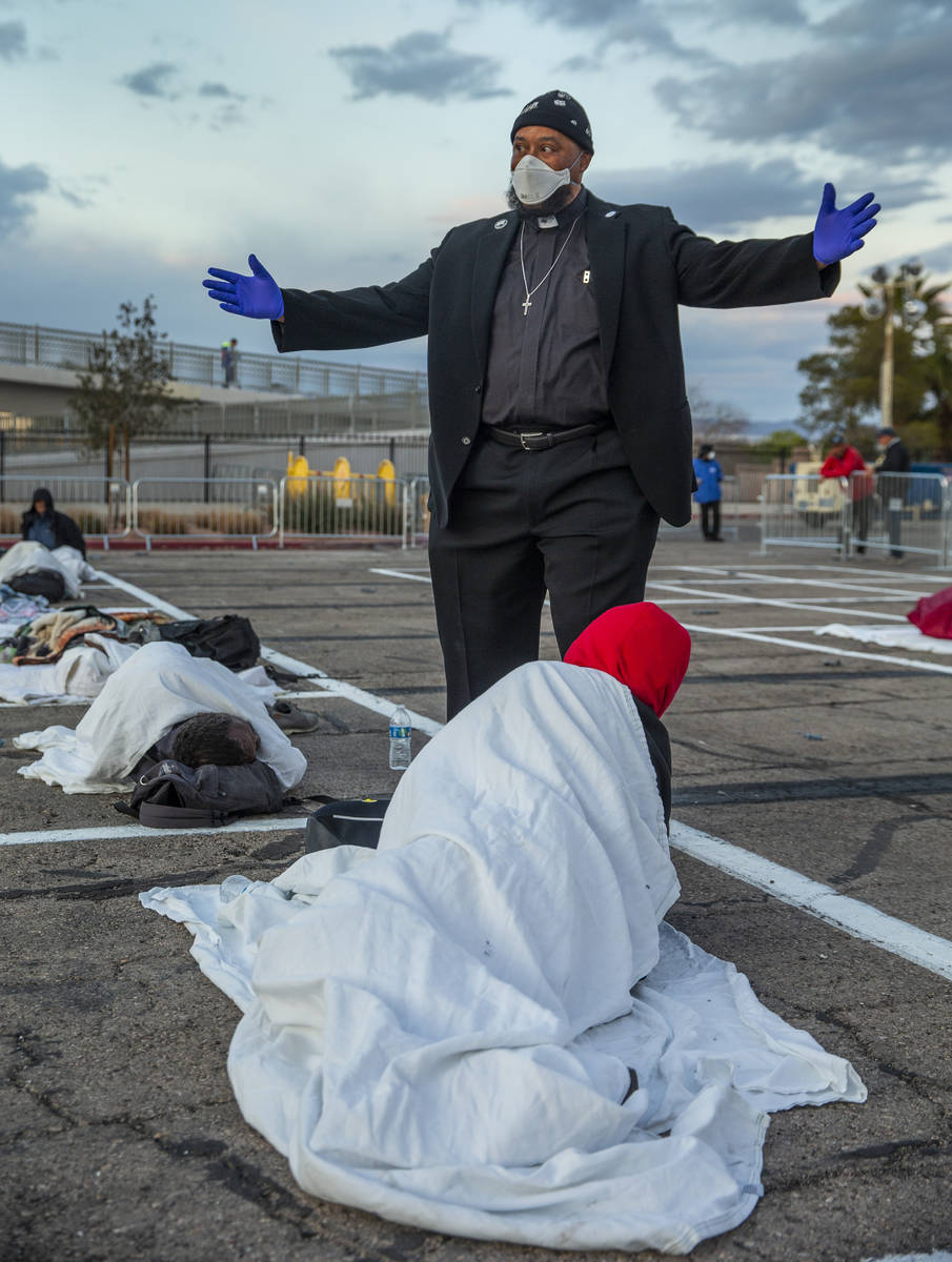 Senior Chaplain Marshaun Winston prays with a homeless man settled in for the night at the temp ...