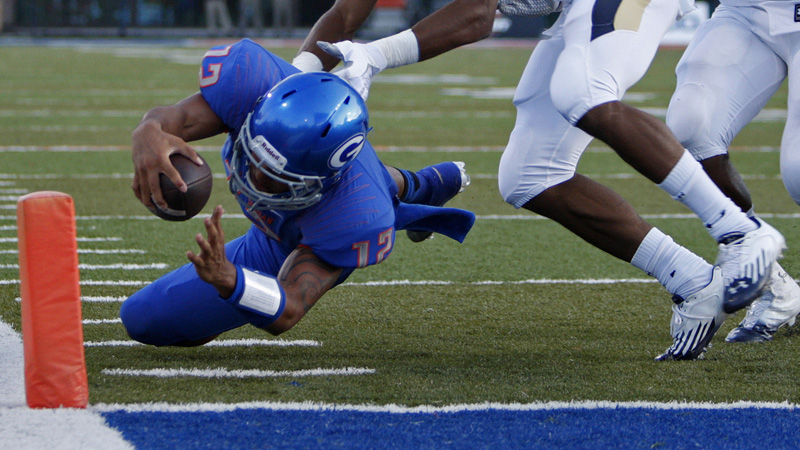 Quarterback Jarrett Solomon of Bishop Gorman High School dives into the end zone for a touch ...