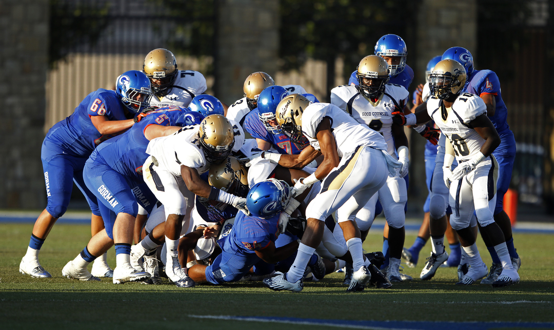 Nathan Starks, bottom center, of Bishop Gorman High School gets tackled by Our Lady of Good ...