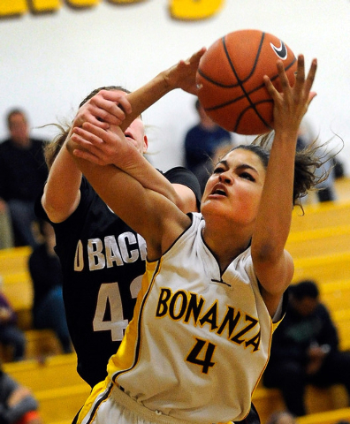 Bonanza’s Sianna Nelson (4) grabs a rebound over Desert Oasis’ Mackenzie Wilcyns ...