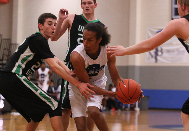 Virgin Valley’s Nathan Hughes, left, and Dillon Graves, right, reach in to defend agai ...