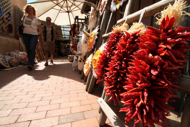 This July 14, 2010 image shows tourists approaching a display of chile ristras at one of the shops near the historic plaza in Santa Fe, N.M. A national historic landmark, the plaza has served as t ...