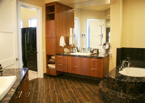 The master bath features a black pebble stone shower floor; split vanities with chocolate brown cabinets, and mirror-mounted chrome light fixtures. Its large walk-in closet has three levels of han ...