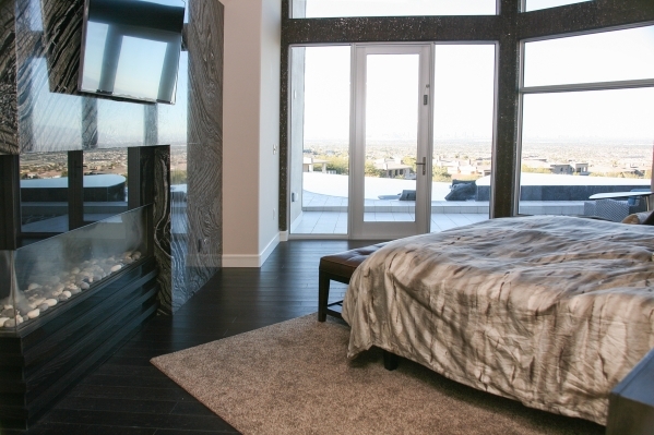 n the master bedroom with a hardwood floor, the bed is oriented to take advantage of the view. Automatic shades provide darkness. The room has a horizontal gas fireplace with a lighter variation o ...