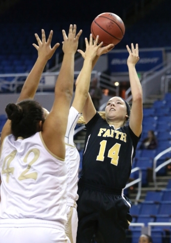 Faith Lutheran‘s Sam Caruth shoots over Spring Valley defenders Myra Tadytin and Essen ...