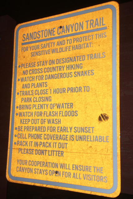 A sign warning hikers is illuminated by a camera flash in the darkness. BRIAN SANDFORD/VIEW