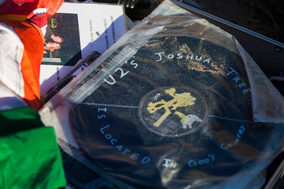 A briefcase with tributes and memorabilia from fans of rock band U2 sits with the fallen tree t ...