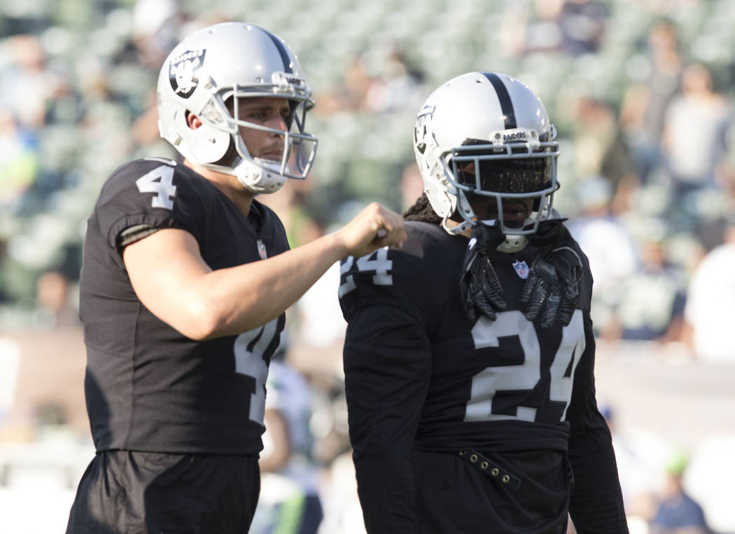 Oakland Raiders quarterback Derek Carr (4) and running back Marshawn Lynch (24) execute drills prior to the preseason game against Seattle Seahawks in Oakland, Calif., Thursday, Aug. 31, 2017. Hei ...