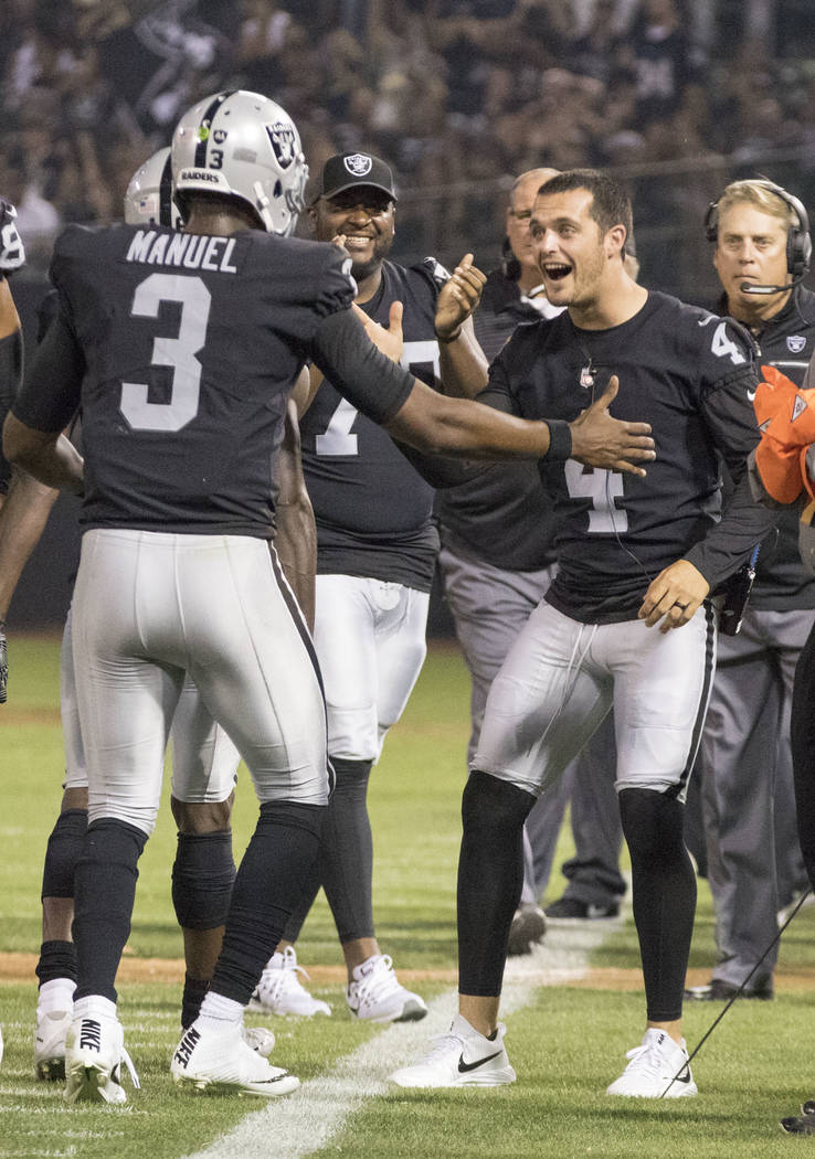 Oakland Raiders quarterback EJ Manuel (3) celebrates scoring a touchdown with quarterback Derek Carr (4) in the first half of the preseason game against the Seattle Seahawks in Oakland, Calif., Th ...
