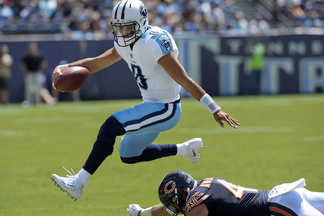 In this Aug. 27, 2017, file photo, Tennessee Titans quarterback Marcus Mariota (8) leaps over Chicago Bears inside linebacker Nick Kwiatkoski (44) in the first half of an NFL football preseason ga ...