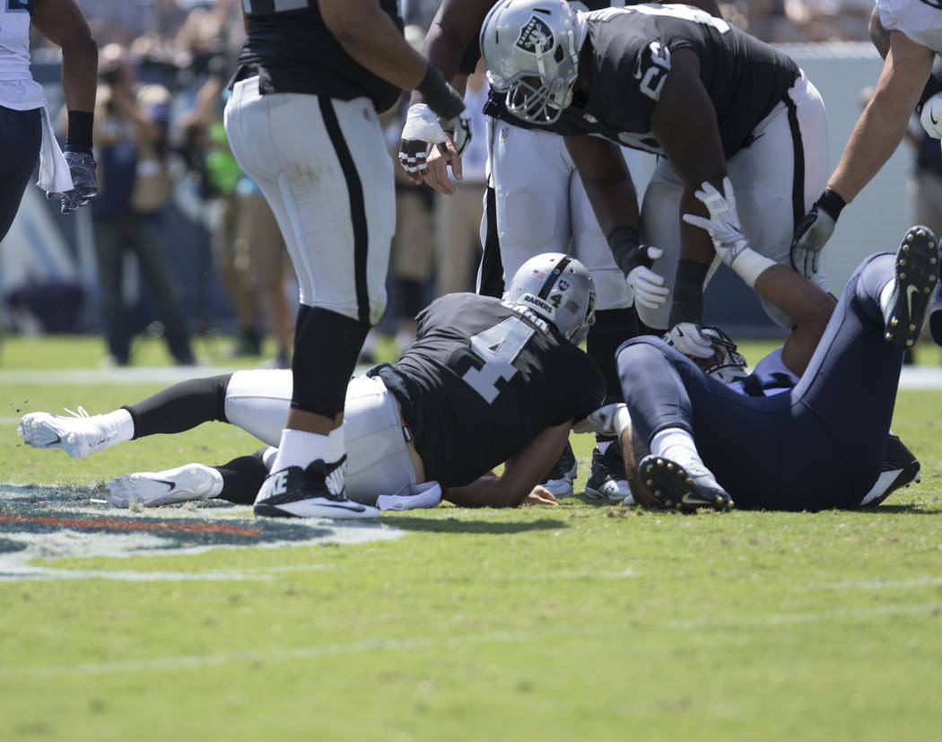 Oakland Raiders quarterback Derek Carr (4) is sacked by Tennessee Titans linebacker Wesley Woodyard (59) in the first half of the game against the Tennessee Titans at the Nissan Stadium in Nashvil ...