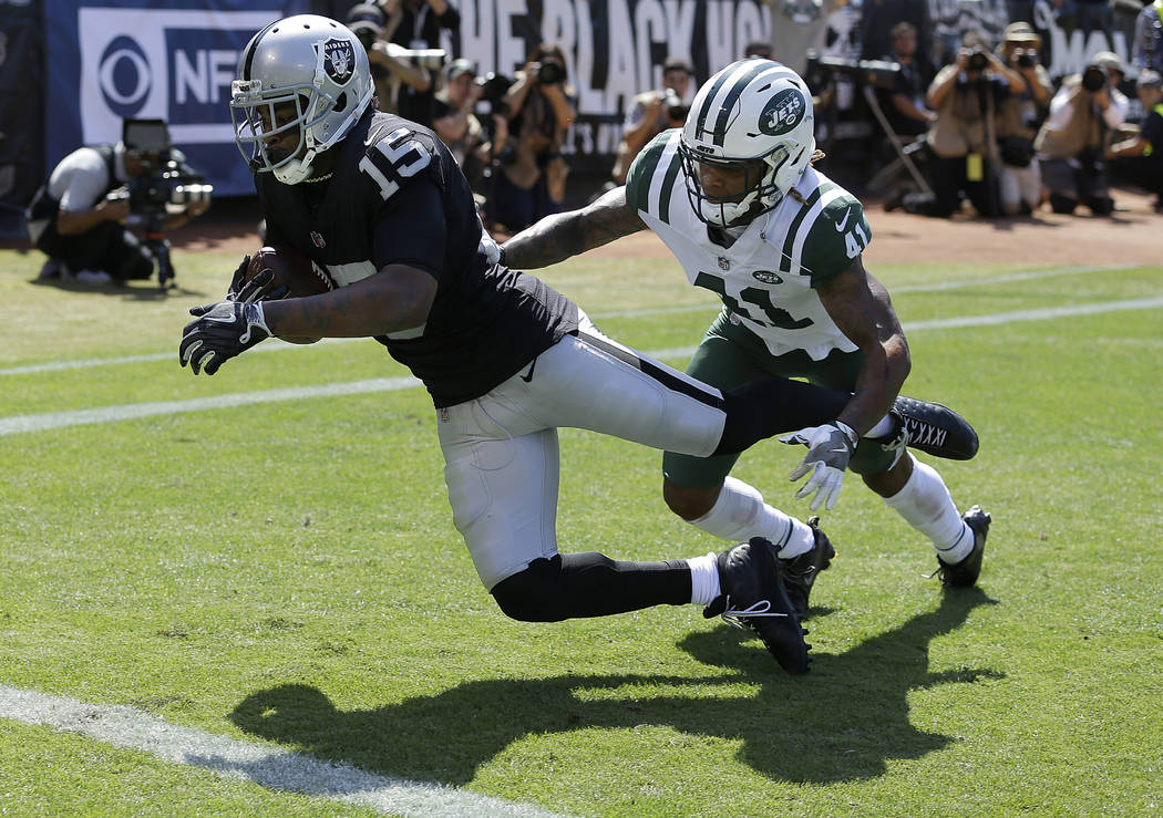 Oakland Raiders wide receiver Michael Crabtree (15) catches a touchdown pass against New York Jets defensive back Buster Skrine (41) during the first half of an NFL football game in Oakland, Calif ...