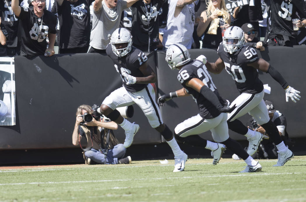 Oakland Raiders wide receiver Johnny Holton (16) celebrates with safety Shalom Luani (26) and linebacker Nicholas Morrow (50) after recovering a muffed punt in the first half of their game against ...