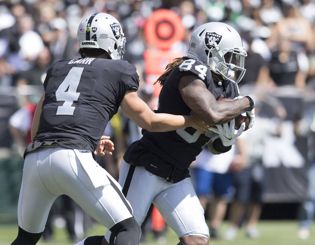 Oakland Raiders quarterback Derek Carr (4) hands off to wide receiver Cordarrelle Patterson (84) in the first half of the game against the New York Jets in Oakland, Calif., Sunday, Sept. 17, 2017. ...