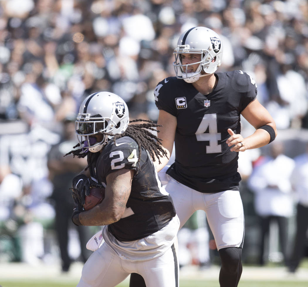 Oakland Raiders quarterback Derek Carr (4) hands off the football to running back Marshawn Lynch (24) in the first half of their game against the New York Jets in Oakland, Calif., Sunday, Sept. 17 ...