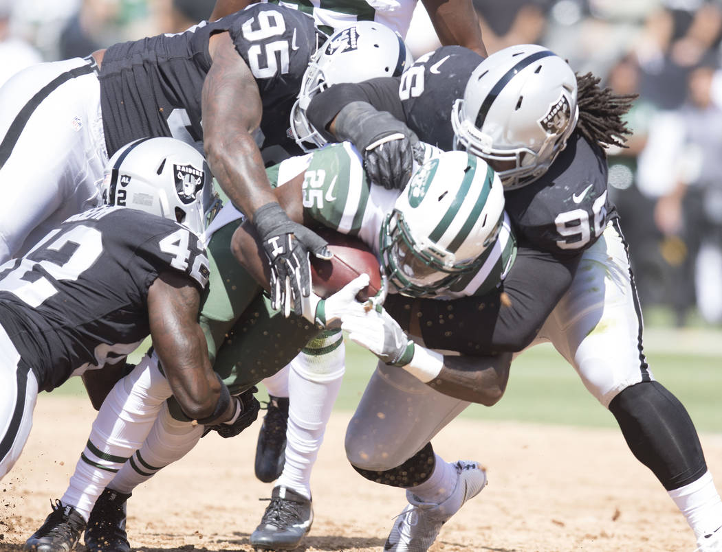 New York Jets running back Elijah McGuire is tackled by Oakland Raiders defensive end Denico Autry (96) defensive end Jihad Ward (95) and strong safety Karl Joseph (42) in the first half of their  ...
