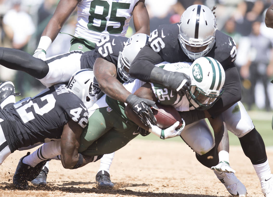 New York Jets running back Elijah McGuire is tackled by Oakland Raiders defensive end Denico Autry (96) defensive end Jihad Ward (95) and strong safety Karl Joseph (42) in the first half of their  ...
