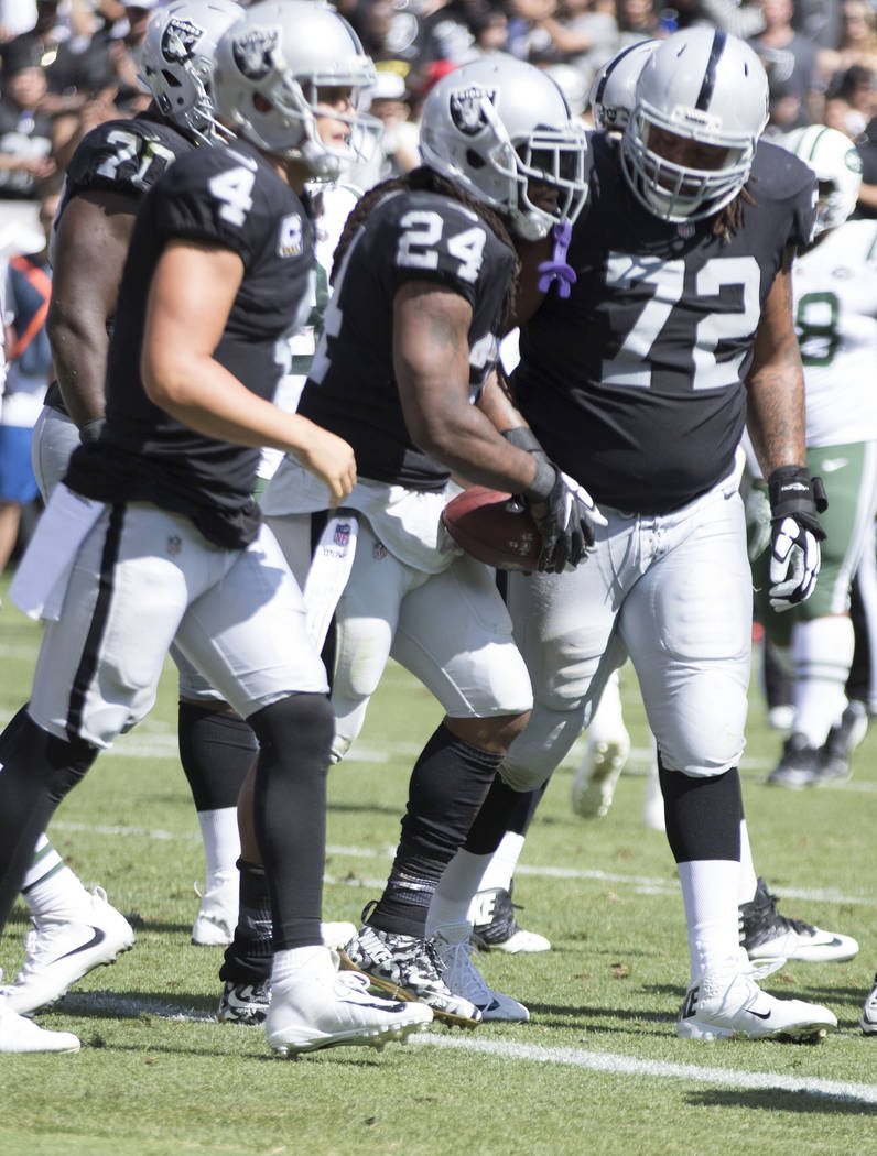 Oakland Raiders running back Marshawn Lynch (24) with quarterback Derek Carr (4) and offensive tackle Donald Penn (72) after scoring in the first half of their game in Oakland, Calif., Sunday, Sep ...