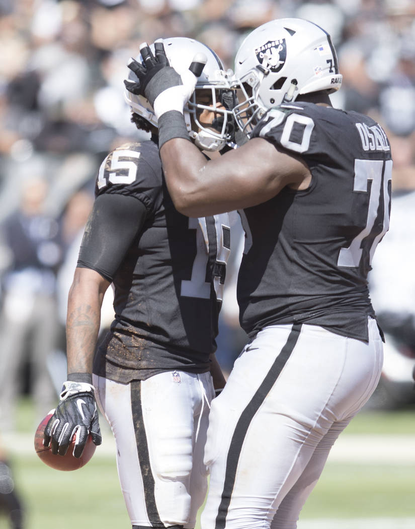 Oakland Raiders offensive guard Kelechi Osemele (70) celebrates with wide receiver Michael Crabtree (15) after a catch in the first half of their game against the New York Jets in Oakland, Calif., ...