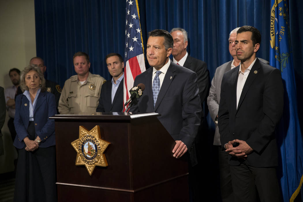 Gov. Brian Sandoval, center, with other state dignitaries, discusses the mass shooting during a press conference at the Las Vegas Metropolitan Police Department headquarters in Las Vegas, Monday,  ...