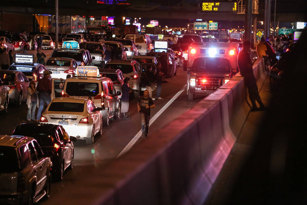 An officer leads an emergency vehicle through stopped traffic on Interstate 15 in Las Vegas after a shooting on the Strip left 58 dead Sunday, Oct. 1, 2017. Joel Angel Juarez Las Vegas Review-Jour ...