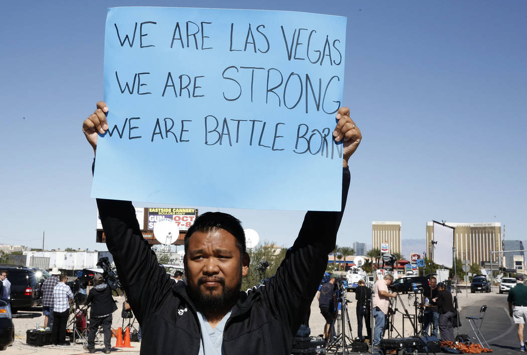 Jon Dimaya, nurse at Sunrise Hospital, holds a sign that reads &quot;We are Las Vegas, We are Strong, We are Battle Born'' on Las Vegas Boulevard near Mandalay Bay hotel-casino on Monday, Oct. ...