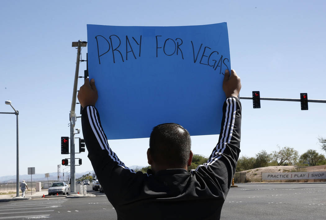 Jon Dimaya, nurse at Sunrise Hospital, holds a sign that reads &quot;Pray for Vegas'' on Las Vegas Boulevard near Mandalay Bay hotel-casino on Monday, Oct. 2, 2017. At least 58 people were kil ...