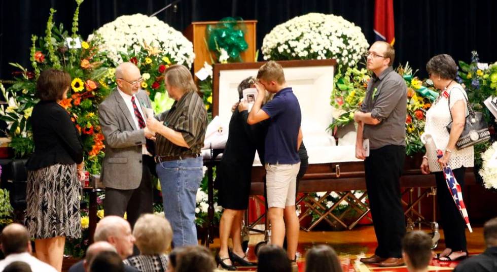 Guests greet family members, from right, Susan Melton, being hugged, father James Melton, grey ...