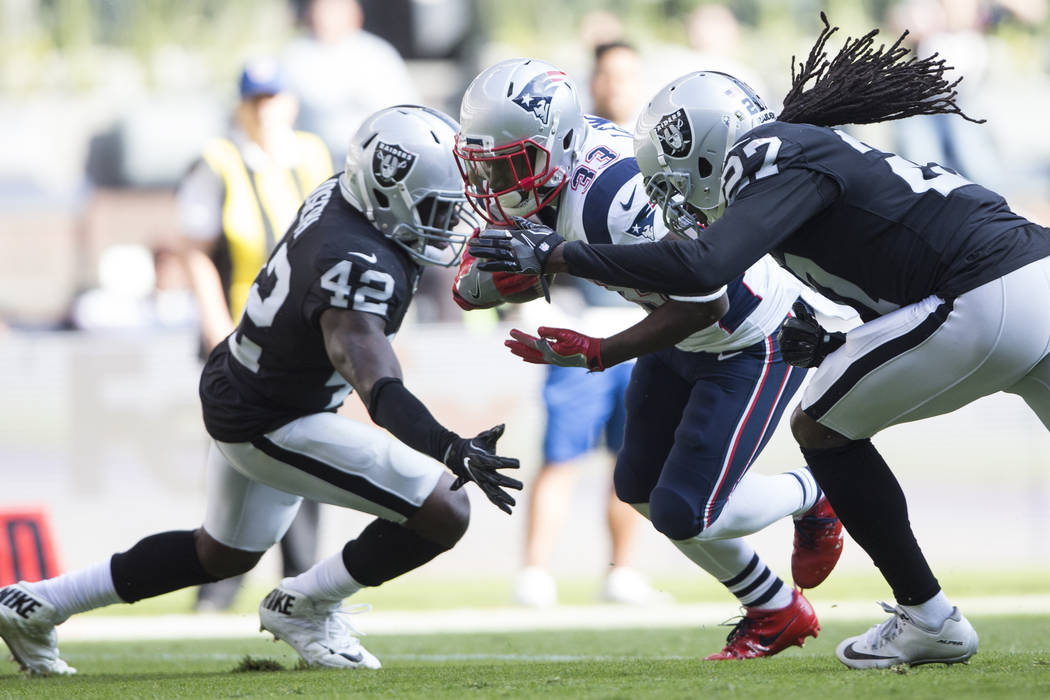 New England Patriots running back Dion Lewis (33) runs the ball for a touchdown against Oakland Raiders strong safety Karl Joseph (42) and Oakland Raiders free safety Reggie Nelson (27) in the NFL ...