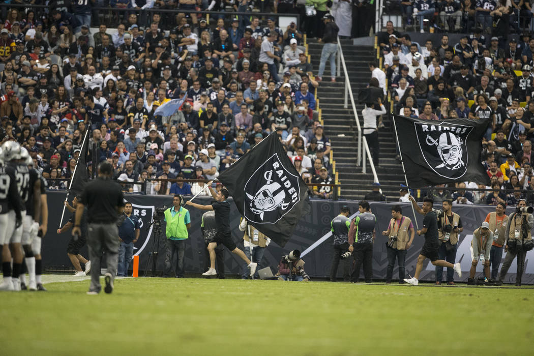 Oakland Raiders flags are waves after their score against the New England Patriots in the NFL football game at Estadio Azteca in Mexico City, Sunday, Nov. 19, 2017. New England Patriots won 33-8.  ...