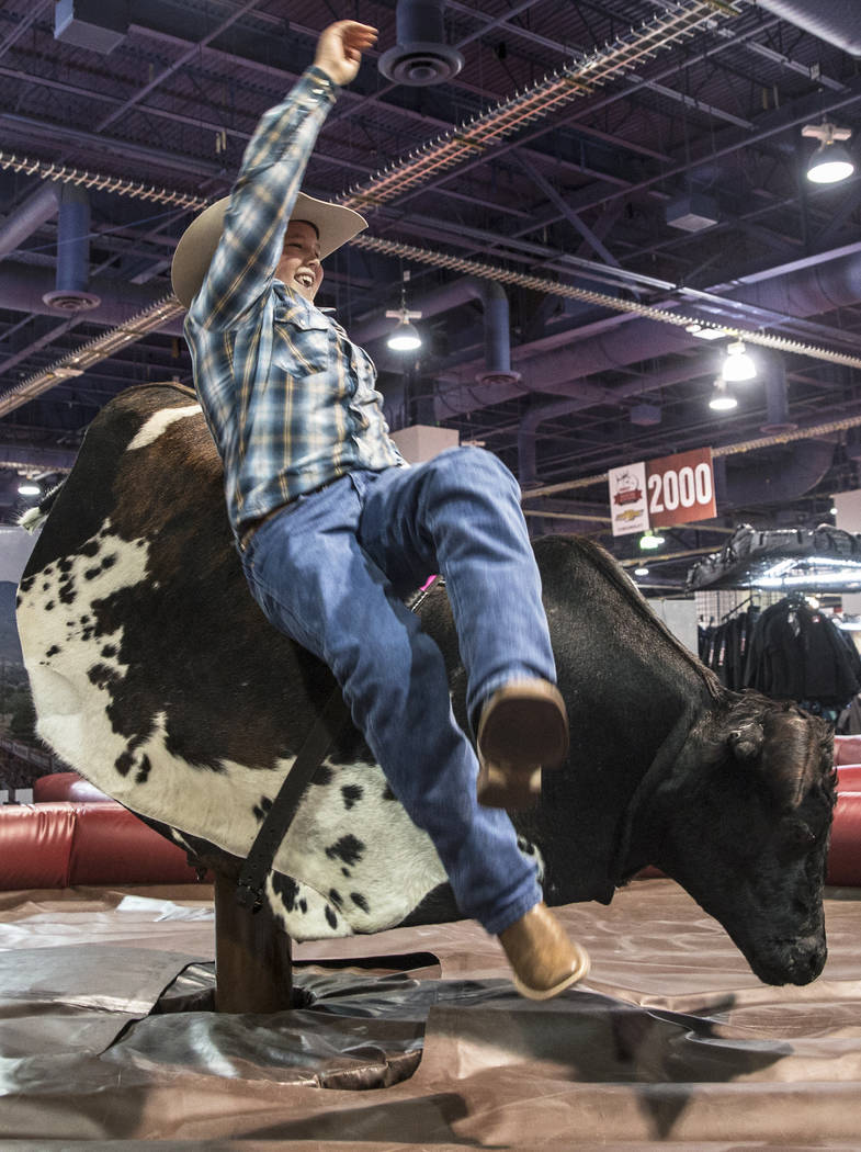 Sam Kofoed gets bucked from a mechanical bull during Cowboy Christmas on Thursday, Dec. 7, 2017 ...