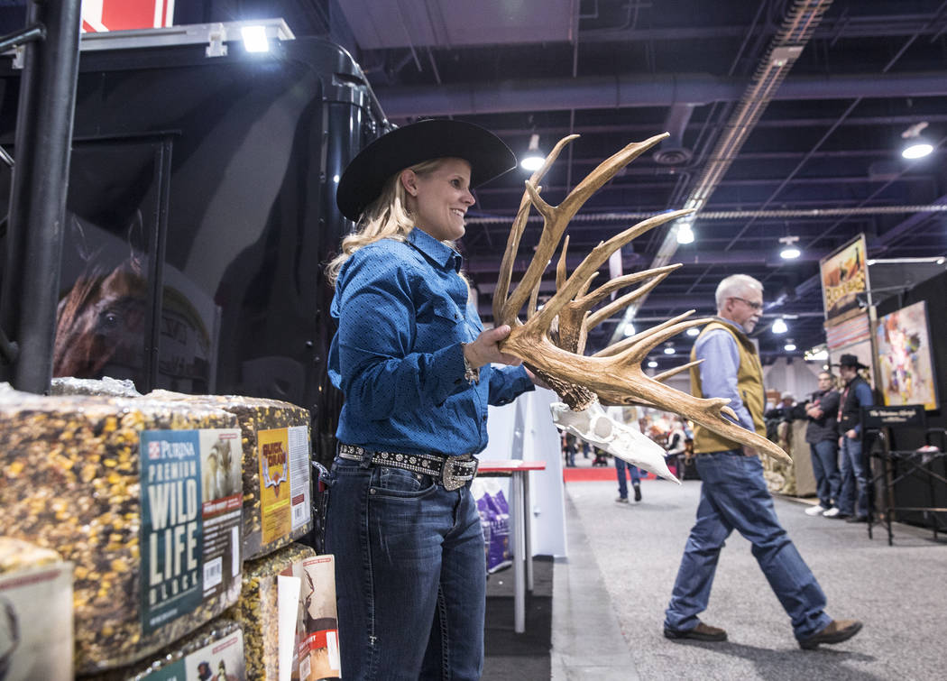 Michelle Coady holds a set of antlers at the Purina feed booth during Cowboy Christmas on Thurs ...