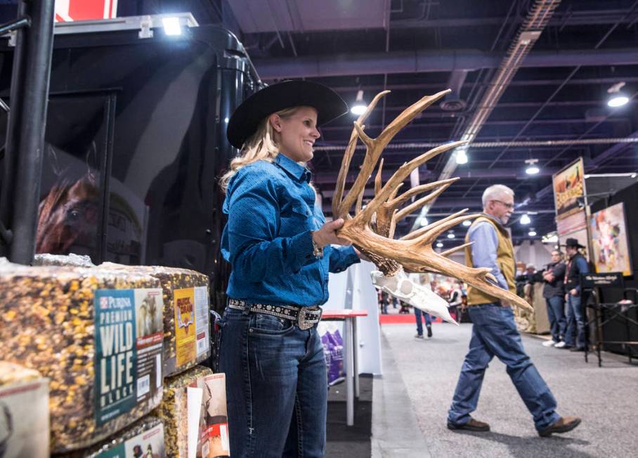 Michelle Coady holds a set of antlers at the Purina feed booth during Cowboy Christmas on Thurs ...