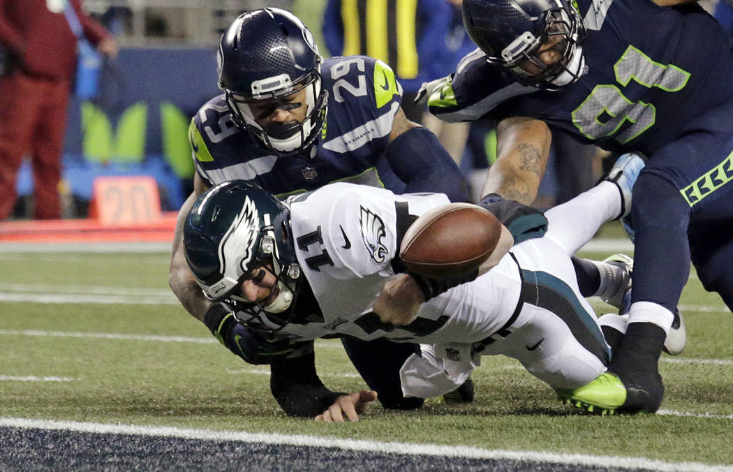 Philadelphia Eagles quarterback Carson Wentz (11) fumbles the ball near the goal line and into the end zone as Seattle Seahawks' Earl Thomas (29) and Sheldon Richardson (91) move in during the sec ...