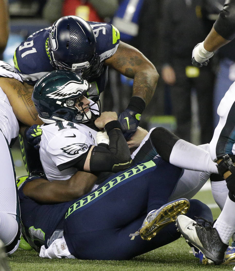 Philadelphia Eagles quarterback Carson Wentz (11) is sacked by Seattle Seahawks defensive tackle Sheldon Richardson (91) and Frank Clark (bottom) in the second half of an NFL football game, Sunday ...