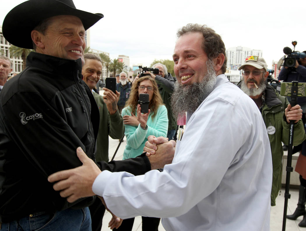 Cliven Bundy supporters Michael Bronson, left, and John Lamb hug outside Lloyd George U.S. Courthouse in Las Vegas Monday, Jan. 8, 2017, after a federal judge dismissed the case with prejudice aga ...