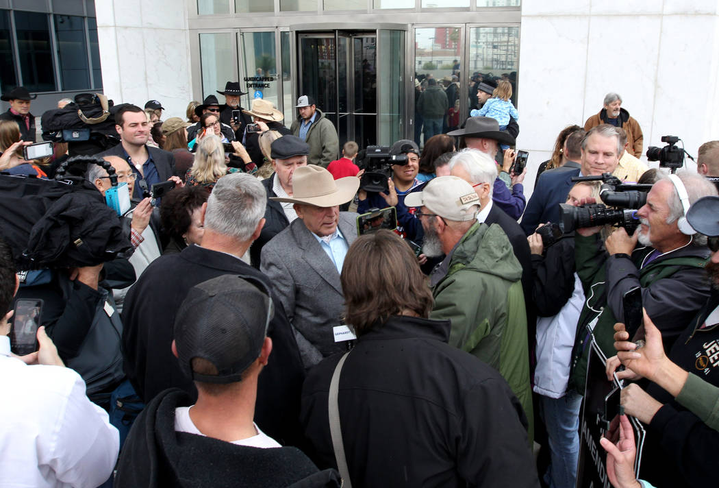 Cliven Bundy, center, talks to the news media after walking out of Lloyd George U.S. Courthouse in Las Vegas a free man Monday, Jan. 8, 2017, after a federal judge dismissed the case with prejudic ...