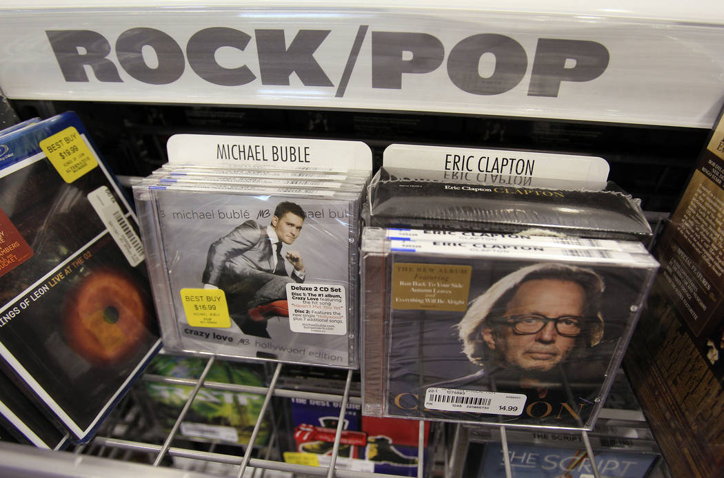 Musicians Eric Clapton, right, and Michael Buble, left, CDs on display at Best Buy in Mountain View, Calif., Friday, May 6, 2011. Warner Music Group Corp.,  the world's third-largest recording com ...