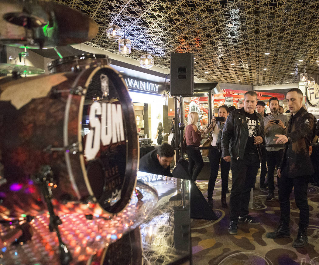 Artist Shepard Fairey, middle, and Sum 41 drummer Frank Zummo point out features of a custom a drumkit/art project called Rise Above on Friday, February 16, 2018, at The Hard Rock hotel-casino, in ...