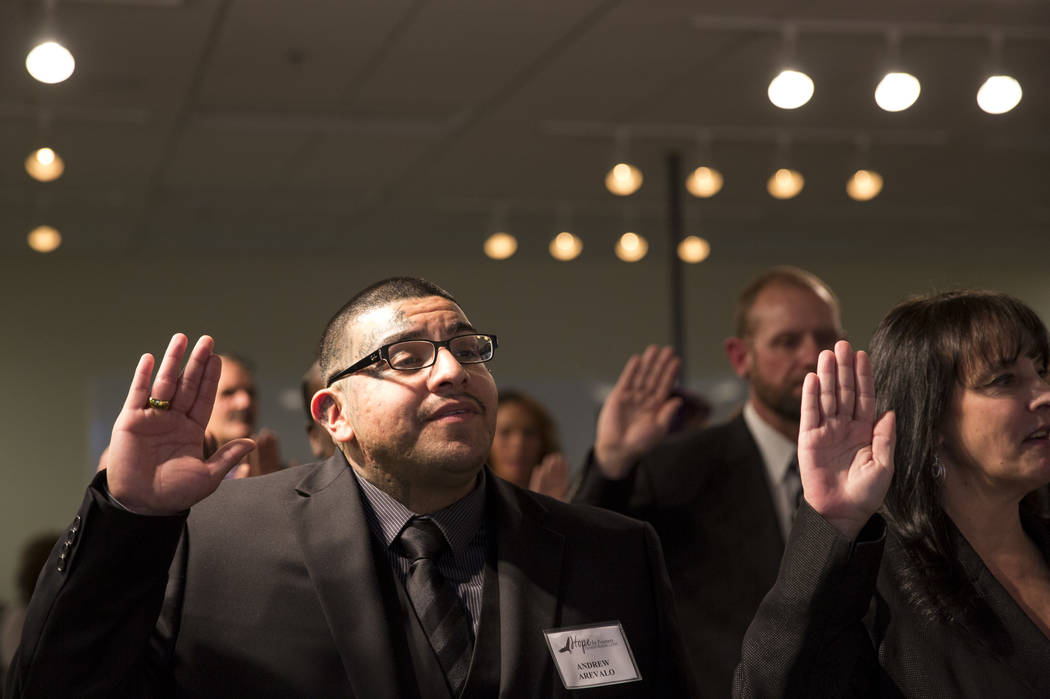 Former gang member Andrew Arevalo, left, and 41 other former and current prisoners are sworn in by District Judge Eric Johnson during the Hope for Prisoners graduation ceremony at the Las Vegas Me ...