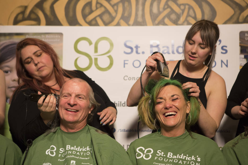 Ben Haynie, left, and Kathy Haynie, right, get their heads shaved in part of "Shave for the Cure" a St. Baldrick's event held at McMullan's Irish Pub on Saturday, March 4, 2017, in Las V ...