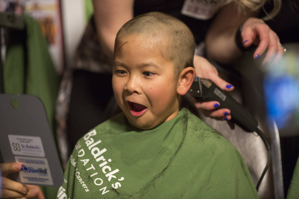 Tayden Nguyen, 7, reacts to seeing his shaved head for the first time in part of "Shave for the Cure" a St. Baldrick's even at McMullan's Irish Pub on Saturday, March 4, 2017, in Las Veg ...