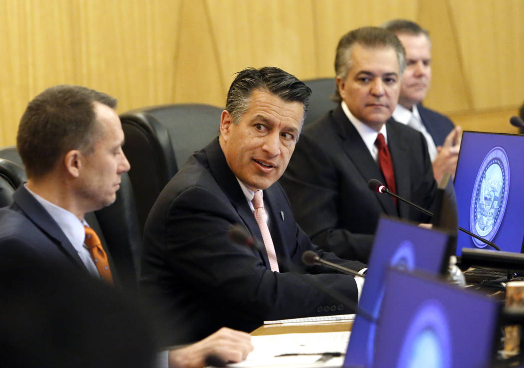 Gov. Brian Sandoval, center, speaks as Gaming Control Board Chairman, A.G. Burnett, left, and Gaming Commission Chairman, Tony Alamo, look on during the Gaming Policy Committee discusses marijuana ...