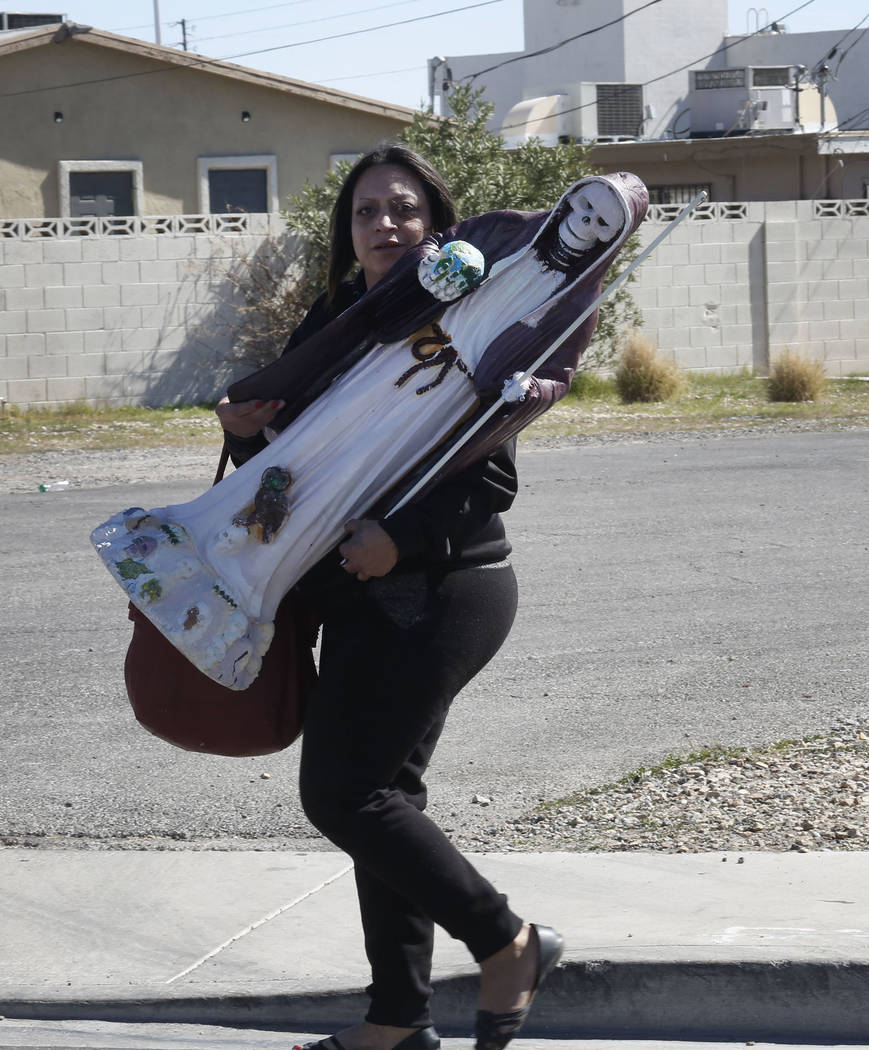Veronica Flores carries her statue after being evicted from Las Haciendas Apartments at 2504 Las Vegas Blvd. North on Monday, March 5, 2018. Twenty-five families were evicted from their apartments ...