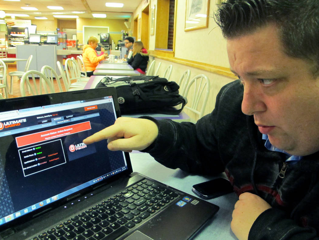 Joseph Brennen tries to log on to a gambling site while at a highway rest stop in Egg Harbor Township N.J., on the first night of New Jersey's Internet gambling test, Nov. 21, 2013. On Thursday, J ...