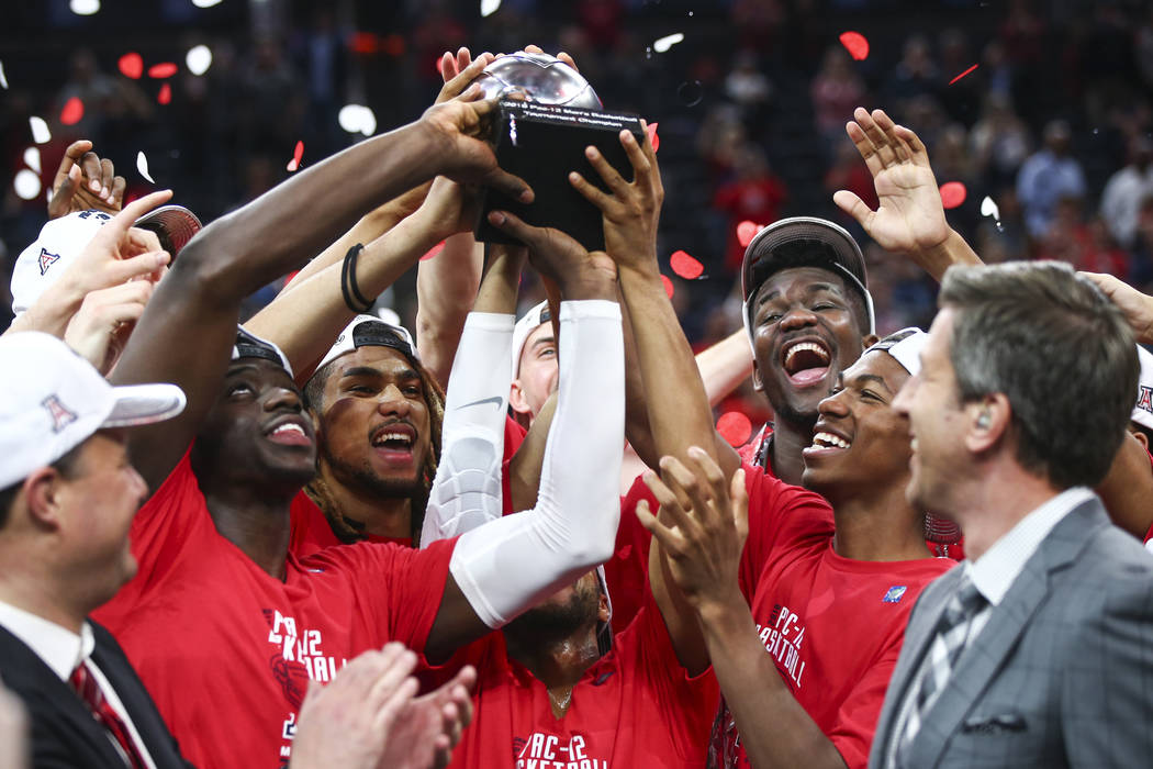 Arizona Wildcats players lift up their trophy after their defeat over the USC Trojans in the Pac-12 tournament championship basketball game at T-Mobile Arena in Las Vegas on Saturday, March 10, 20 ...