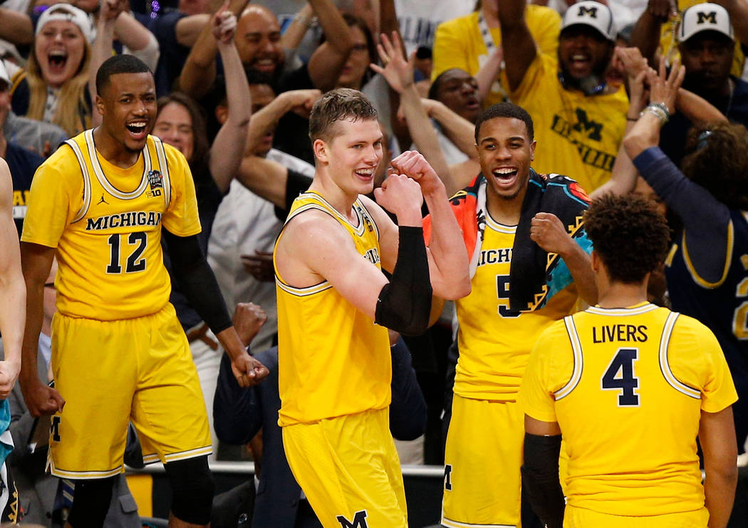 Michigan's Moritz Wagner, second from left, celebrates with his teammates during the second half in the semifinals of the Final Four NCAA college basketball tournament against Loyola-Chicago, Satu ...