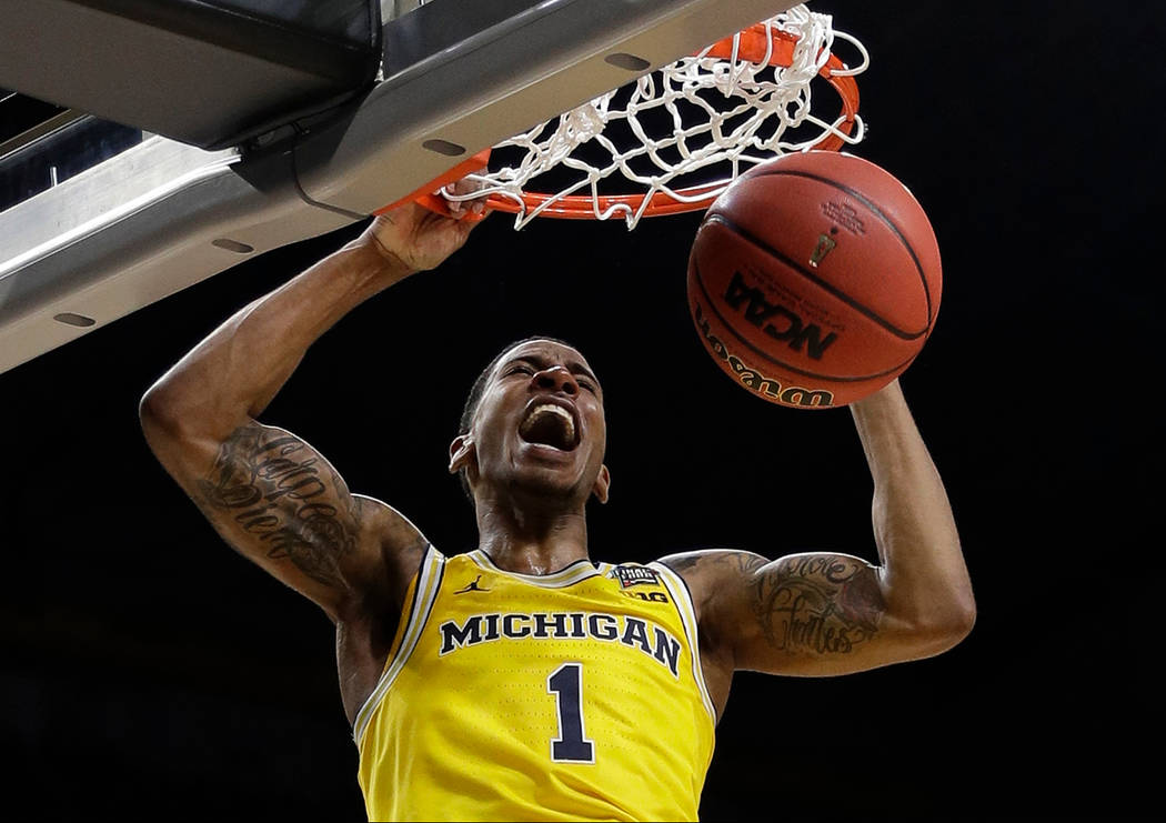 Michigan's Charles Matthews (1) dunks during the second half in the semifinals of the Final Four NCAA college basketball tournament against Loyola-Chicago, Saturday, March 31, 2018, in San Antonio ...